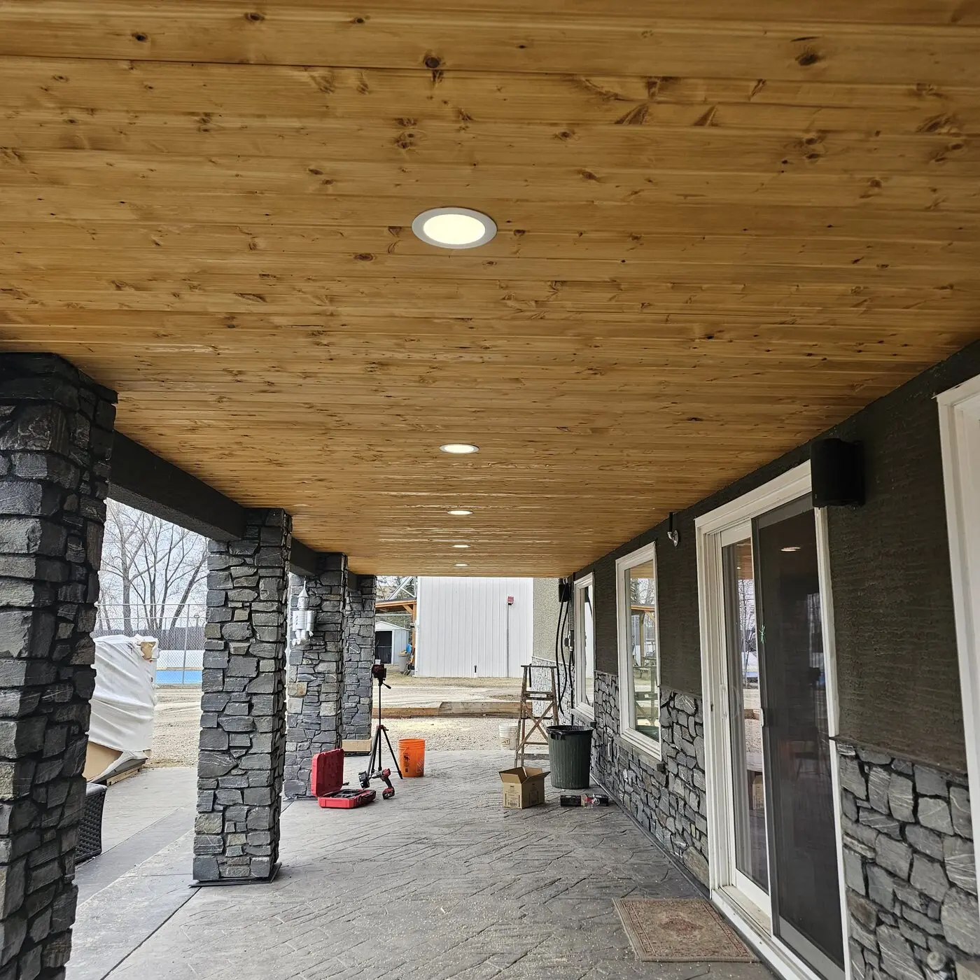 Recessed lighting installed in a finished wood patio ceiling