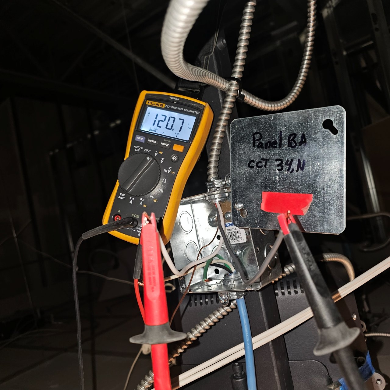 Fluke multimeter measuring voltage at an electrical junction box